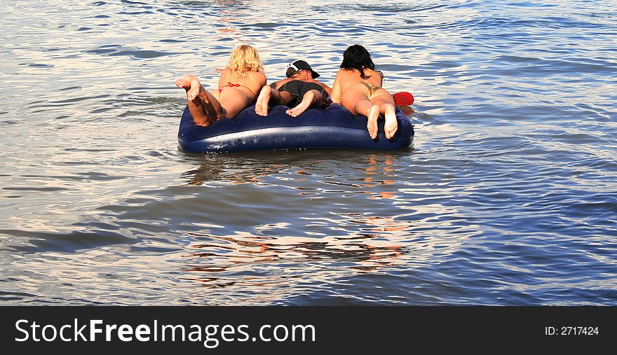 On a photo people are represented floating on a water mattress. On a photo people are represented floating on a water mattress