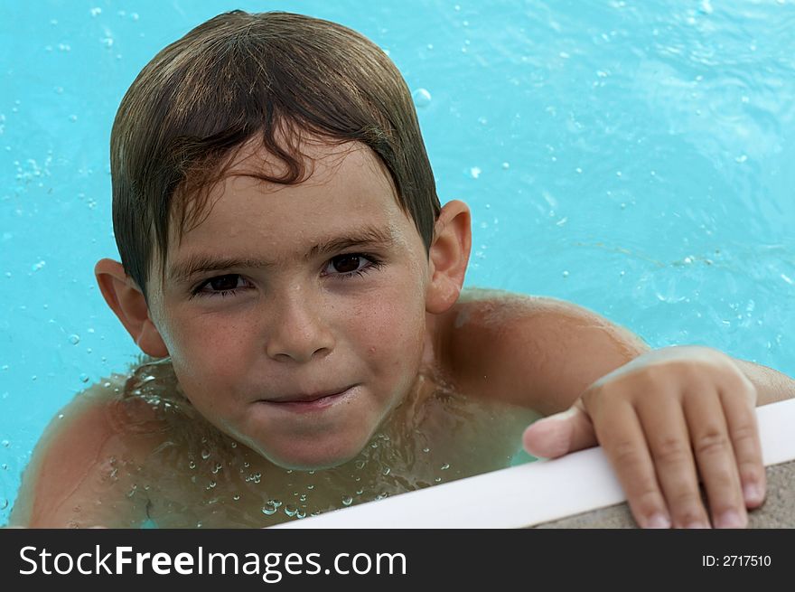 Young boy smiling in pool water. Young boy smiling in pool water