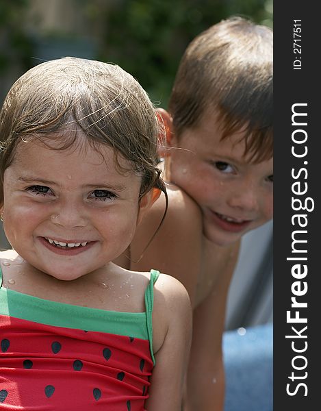 Young girl and boy smiling in pool water. Young girl and boy smiling in pool water