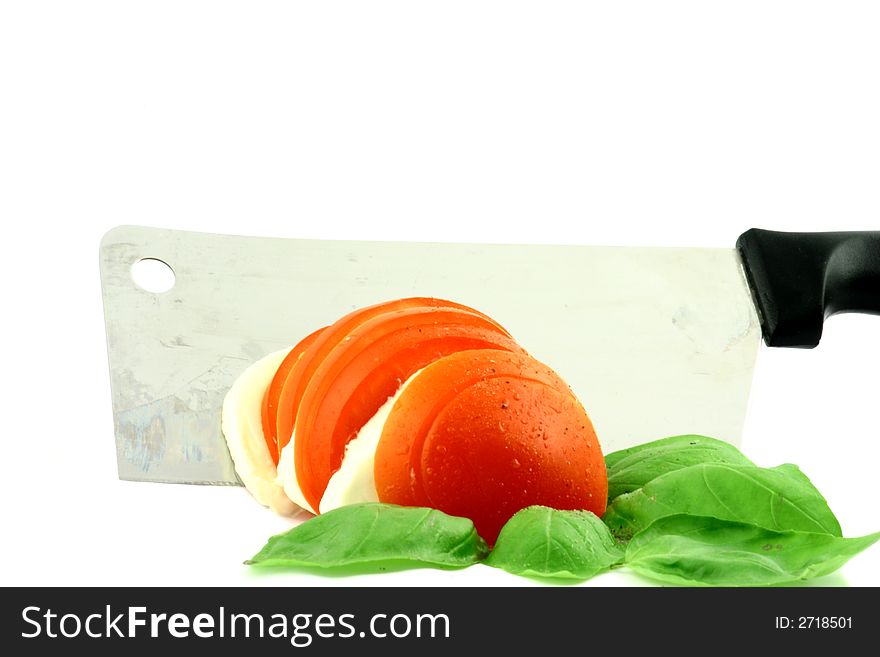 Tomato and feta meal surrounded with basil with cleaver on a white background. Tomato and feta meal surrounded with basil with cleaver on a white background
