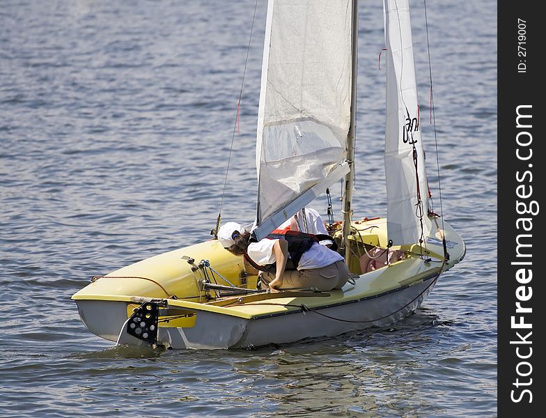 Young girl sailing with a little pleasure yacht on a lake. Young girl sailing with a little pleasure yacht on a lake