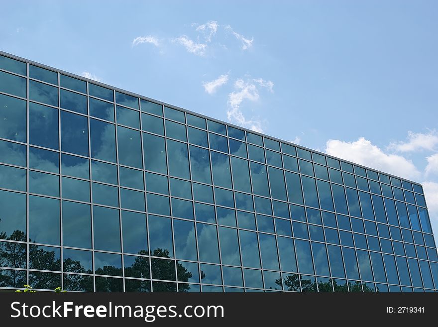 Blue glass office building reflecting the sky with clouds. Blue glass office building reflecting the sky with clouds