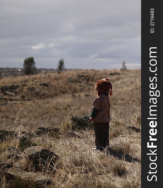 A little boy ponders the land around him trying to determine the best way to go home. A little boy ponders the land around him trying to determine the best way to go home.