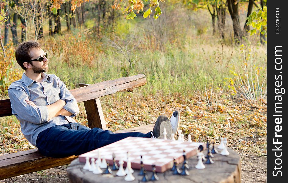 Man relaxing waiting for a chess opponent