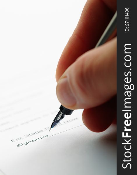 Closeup of a man holding a pen while doing document. Shot with shallow depth of field.