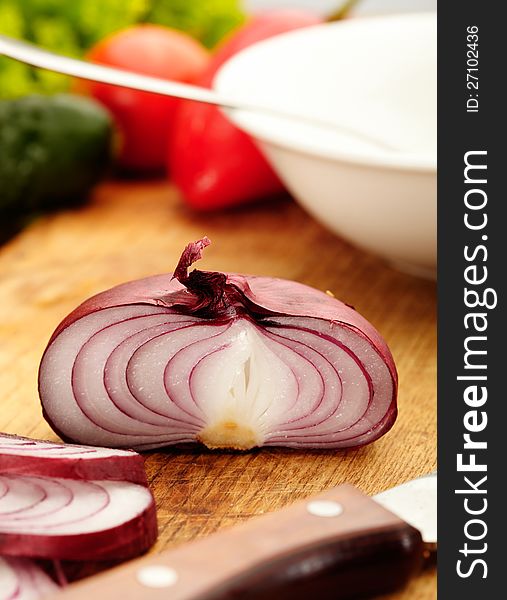 Red onion, sliced in half with vegetable on background. Red onion, sliced in half with vegetable on background