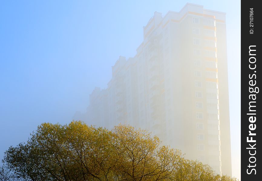 Autumn in the city: the house in a mist and trees