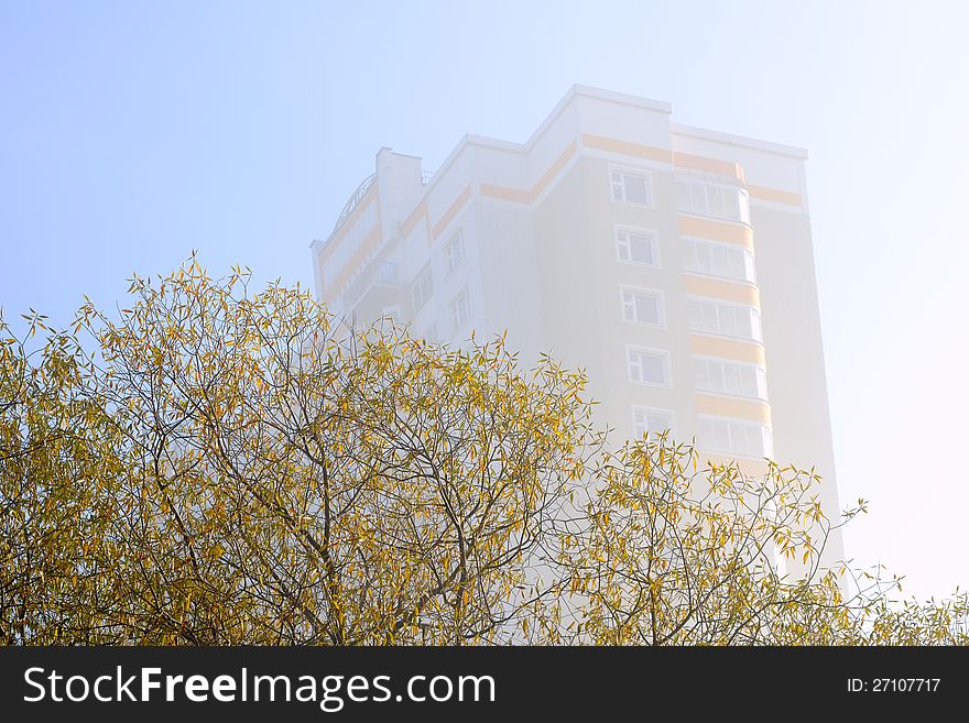 Autumn in the city: the house in a mist and trees