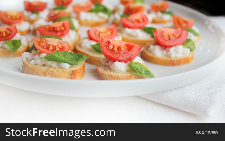 Italian bruschetta with cherry tomato,basil and cheese on white plate