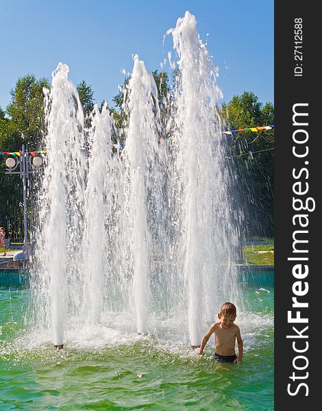 Children bathe in a fountain on embankment Komsomolsk-na-Amure in hot summer day. Children bathe in a fountain on embankment Komsomolsk-na-Amure in hot summer day