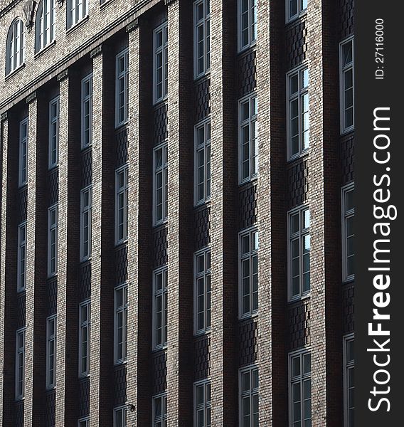 The morning sun creates a gilded effect on the columns of a multistory brick building. The morning sun creates a gilded effect on the columns of a multistory brick building