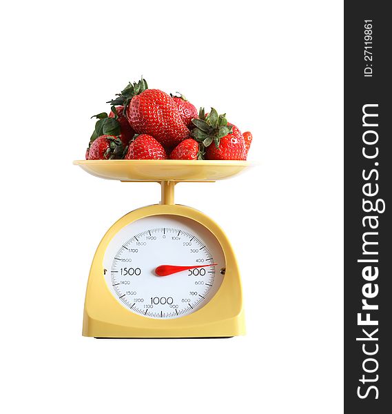 Heap of strawberry fruits lying on nice yellow kitchen scale. Isolated on white with clipping path. Heap of strawberry fruits lying on nice yellow kitchen scale. Isolated on white with clipping path