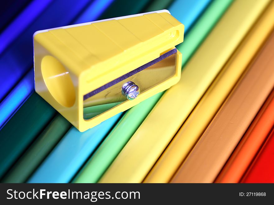 Closeup of yellow sharpener on color pencils surfase. Closeup of yellow sharpener on color pencils surfase