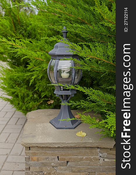Beautiful small lamp on a pedestal in park. Beautiful small lamp on a pedestal in park