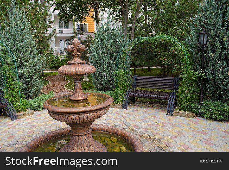 Fine bronze Fountain in park among trees