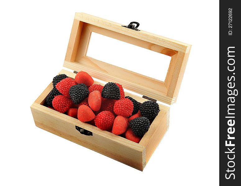 A wooden box with candies of black and red colors isolated on a white background. A wooden box with candies of black and red colors isolated on a white background