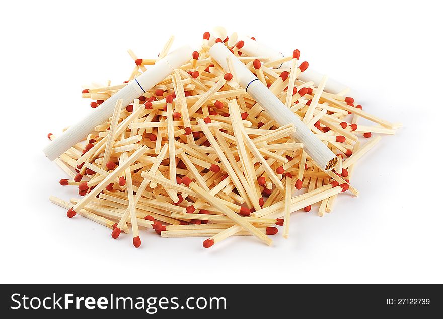 A pile of matches with cigarettes on top isolated on a white background