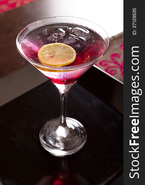 Brightly lighted pink drink in martini cocktails with lemon