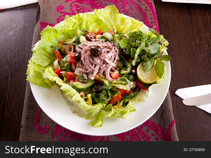 Salad with mixed lettuce, ham, olives, Lemon, avocado, cherry tomatoes, and a creamy dressing.