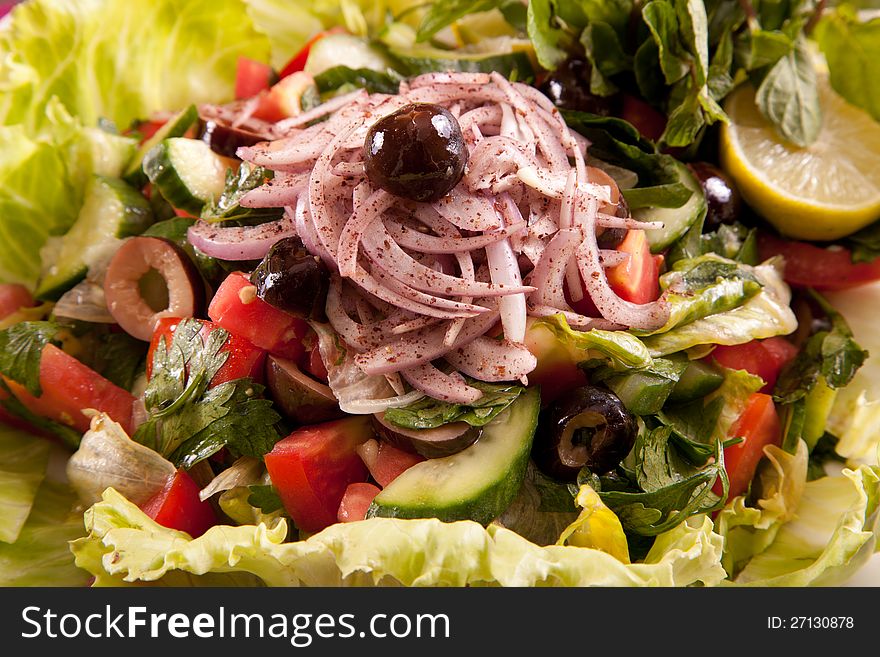Salad with mixed lettuce, ham, olives, Lemon, avocado, cherry tomatoes, and a creamy dressing closeup. Salad with mixed lettuce, ham, olives, Lemon, avocado, cherry tomatoes, and a creamy dressing closeup