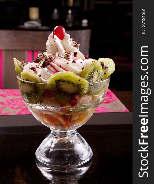 Fruit salad topped with cream and grapes and kiwi. Fruit salad topped with cream and grapes and kiwi