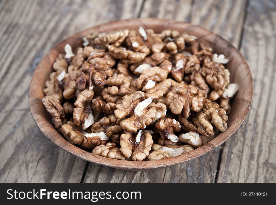 Walnut in wooden bowl on wooden table