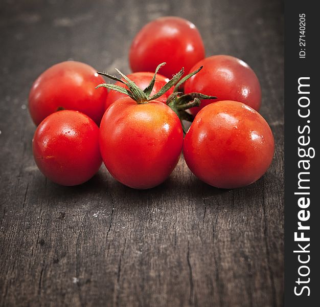 Fresh cherry tomatoes on an old chopping board.