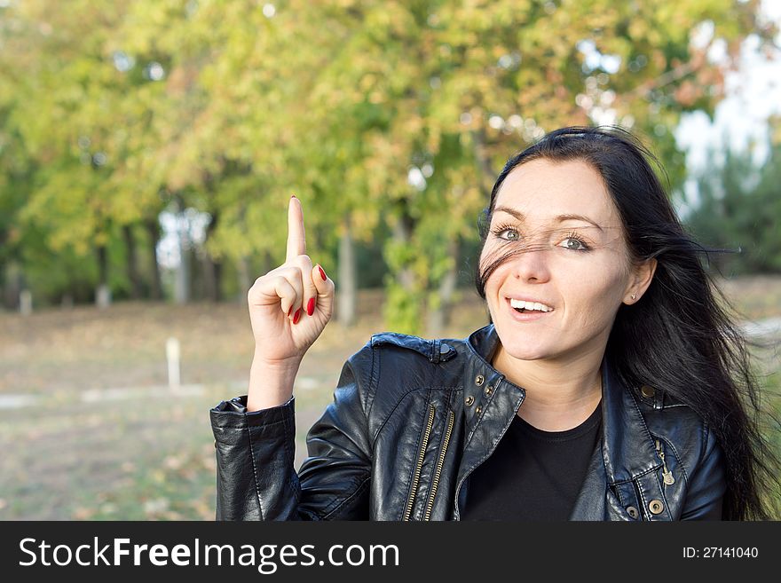Young woman in a park with an idea, pointing her finger up. Young woman in a park with an idea, pointing her finger up.