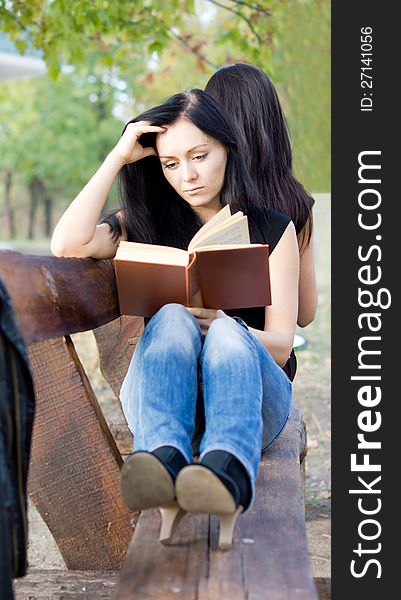 Girl reading a book on a bench