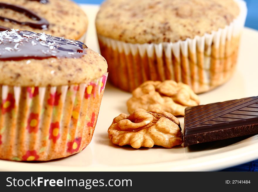 Group of muffins on a plate with dark chocolate and walnuts