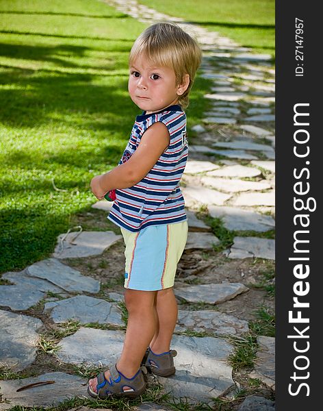 Boy on Curved Stone Chip Path on Grass Lawn in Park