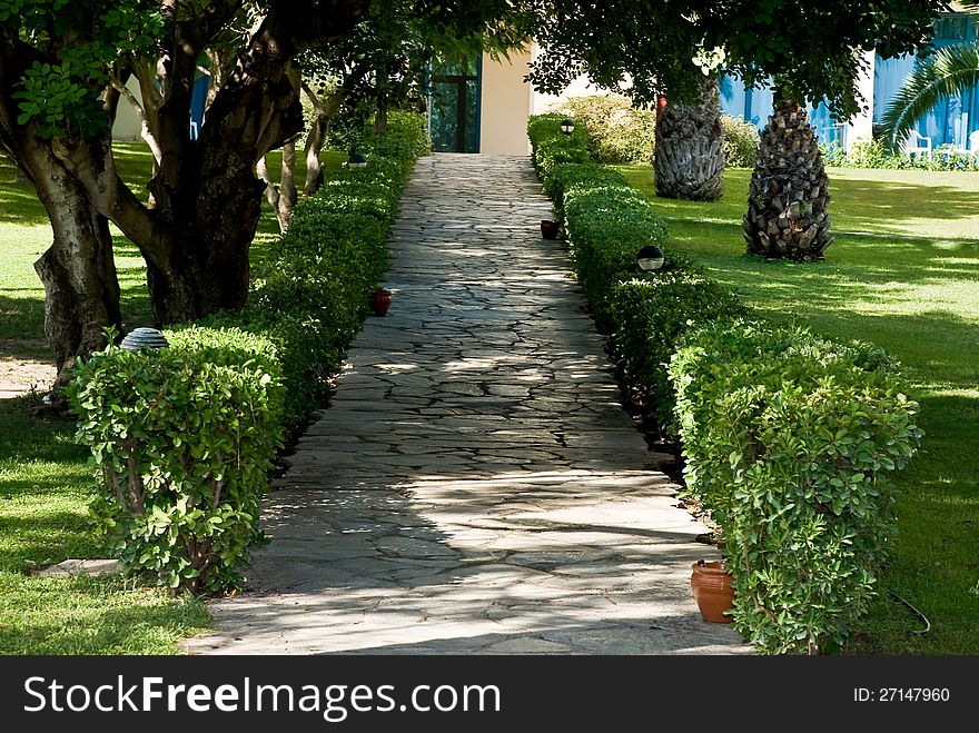 Corridor in a park with green meadows and trees around