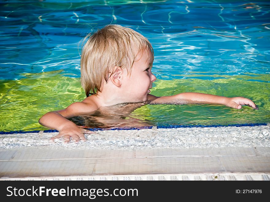 Young smiling boy in the swimming pool