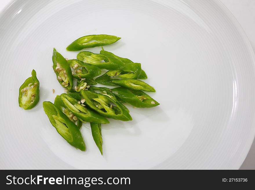 Green chili in white plate on white background