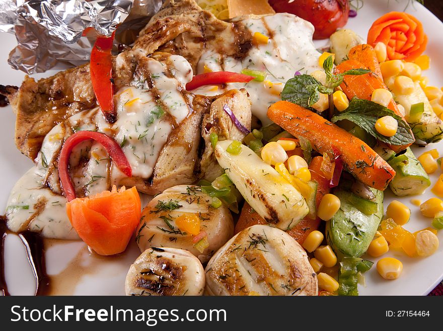 Italian Chicken with Vegetables Meal in white dish Close up. Italian Chicken with Vegetables Meal in white dish Close up