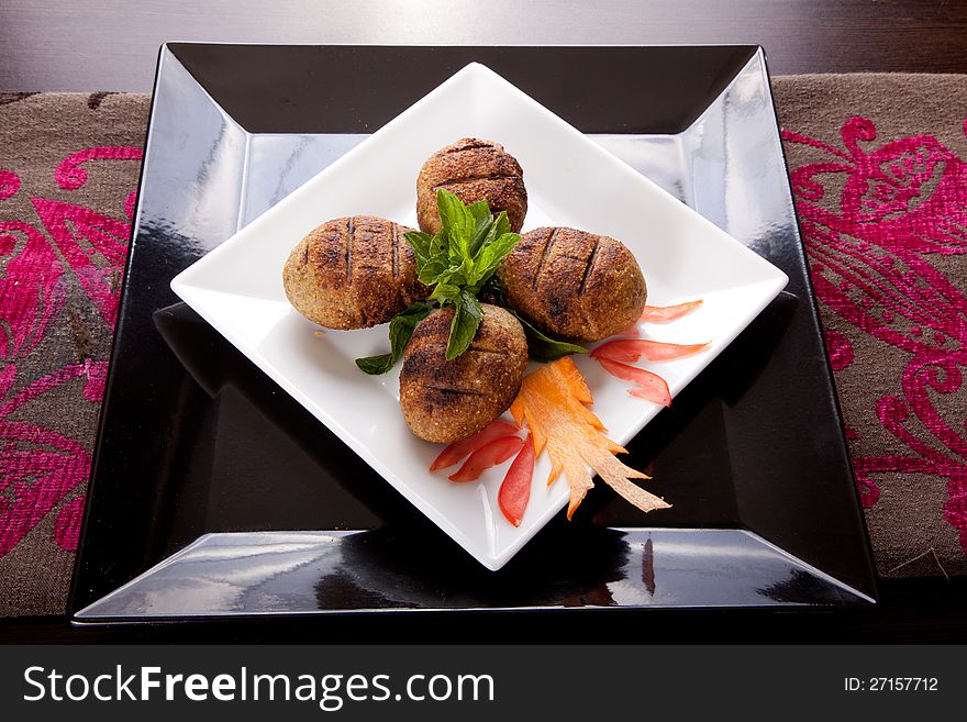 Oriental grilled meat balls on white dish and black underline ( Kebab ). Oriental grilled meat balls on white dish and black underline ( Kebab )