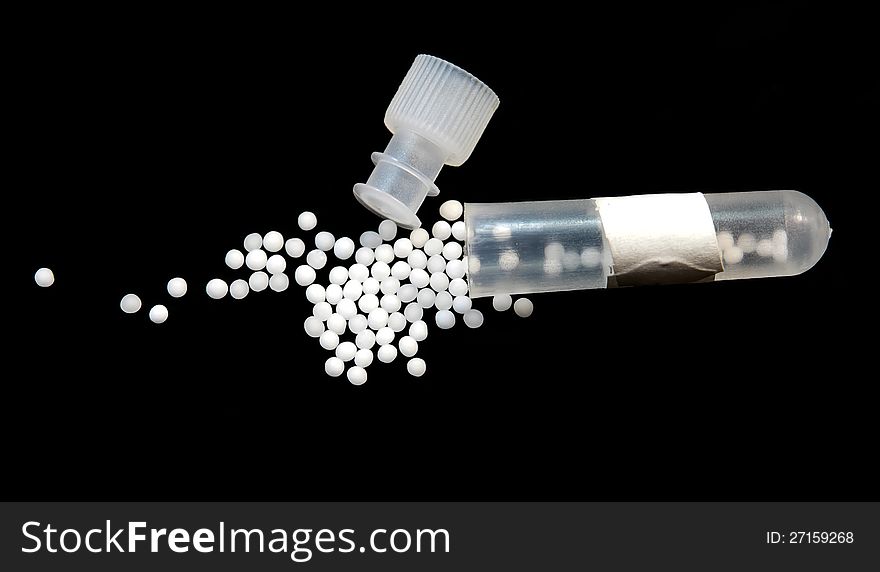 Homeopathic pills with tube isolated on black