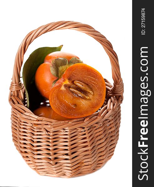 Persimmons in a basket on a white background. Persimmons in a basket on a white background