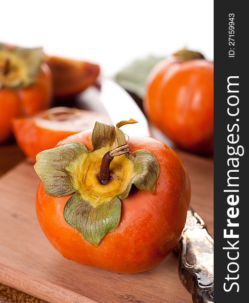 Ripe persimmon on a wooden board and vintage knife