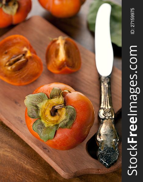 Ripe persimmon on a wooden board