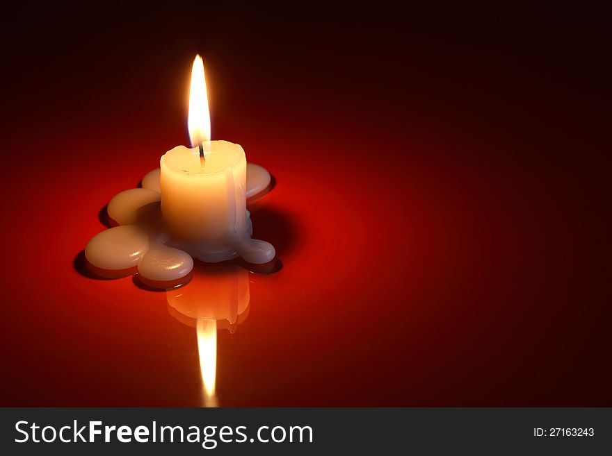 One lighting candle on dark background with free space for text
