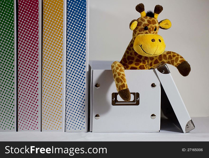 Plush giraffe sits smiling in a drop box. Plush giraffe sits smiling in a drop box.