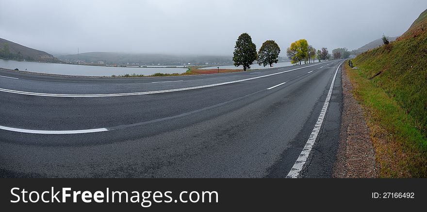 Autumn colors along a road on a foggy morning. Autumn colors along a road on a foggy morning