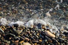 Crystal Clear Water On The Seashore. The Beach Is Lined With Small Colorful Pebbles. Sea Foam From The Waves. Royalty Free Stock Photo Crystal Clear Water On The Seashore. The Beach Is Lined With Small Colorful Pebbles. Sea Foam From The Waves. Royalty Free Stock Photo