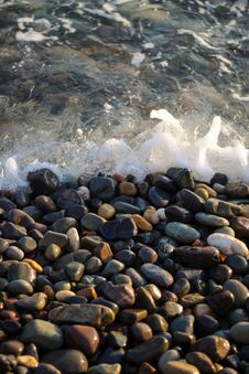 Sea Foam From Small Waves. Crystal Clear Water On The Seashore. The Beach Is Lined With Small Colorful Pebbles. Royalty Free Stock Images Sea Foam From Small Waves. Crystal Clear Water On The Seashore. The Beach Is Lined With Small Colorful Pebbles. Royalty Free Stock Images