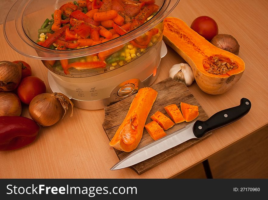 Cutting up vegetables and cooking in a steam pot. Cutting up vegetables and cooking in a steam pot