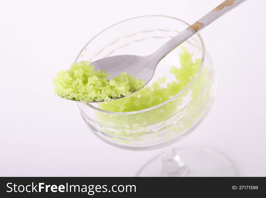 Tobiko green caviar in a spoon and glass.