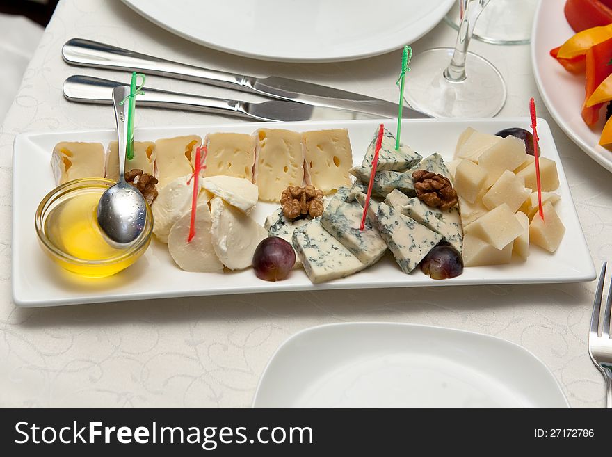 Cheese plate with honey on restaurant table. Cheese plate with honey on restaurant table