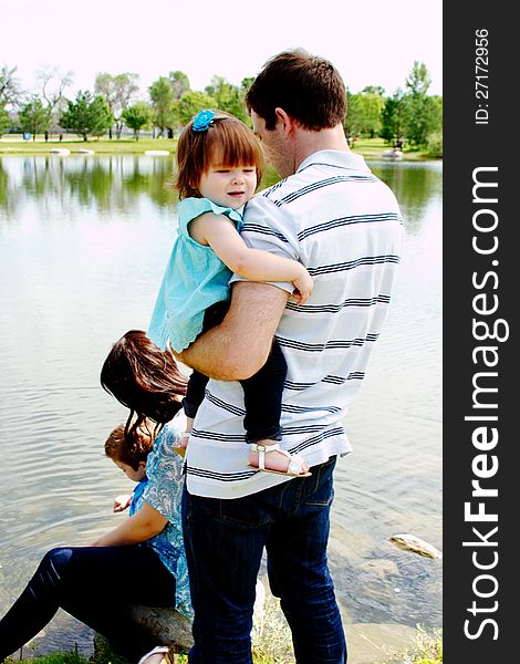 Family playing at park near water. Family playing at park near water