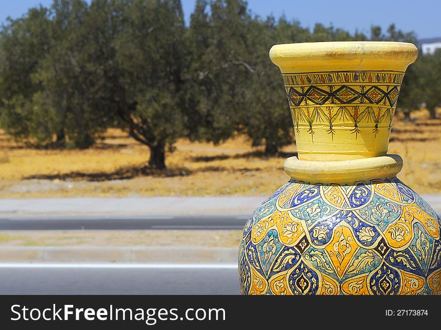 Tunisian pot wid olives tree on background